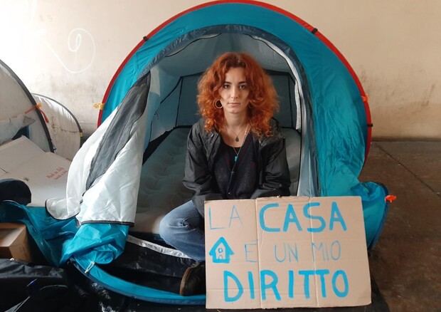 ragazza protesta contro il caro affitti