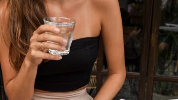 giovane donna beve un bicchiere di acqua