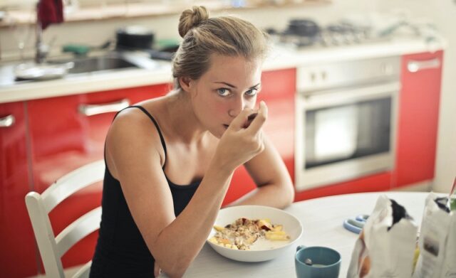 giovane donna fa colazione in cucina