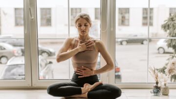 giovane donna pratica yoga con dei leggings a vita alta neri