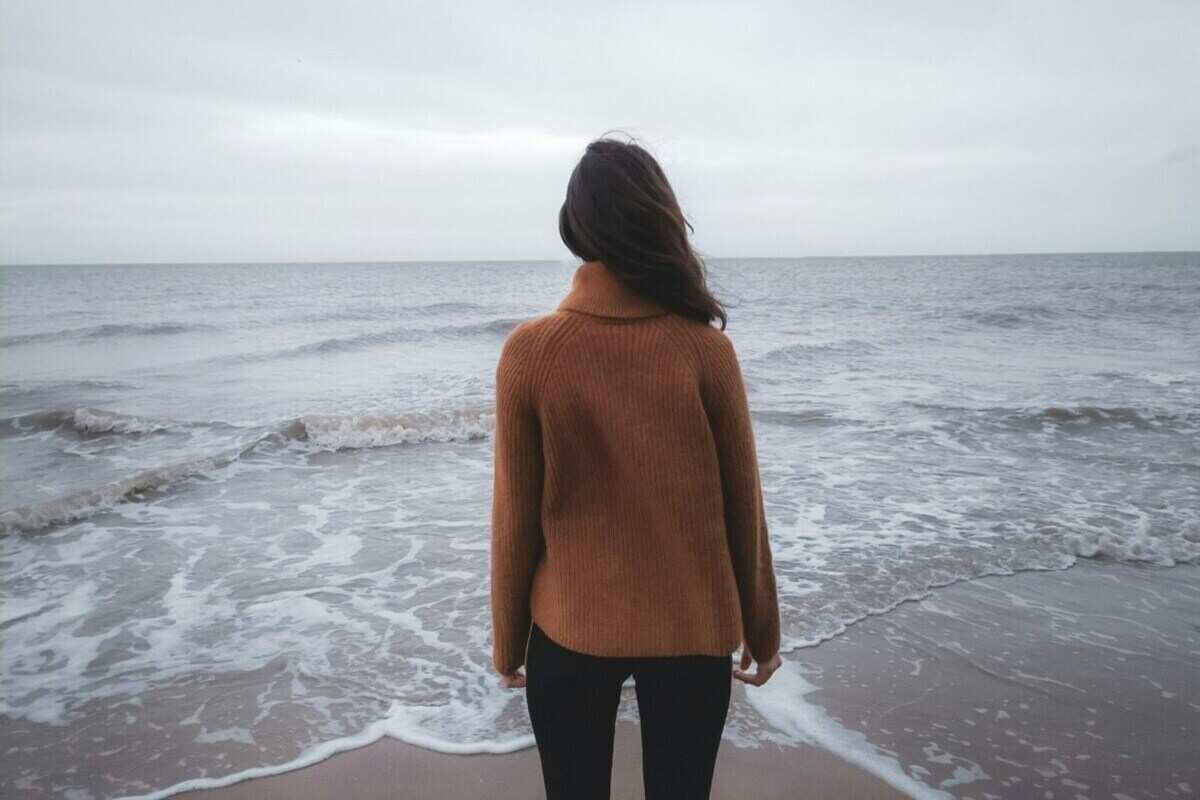 una ragazza di spalle davanti al mare